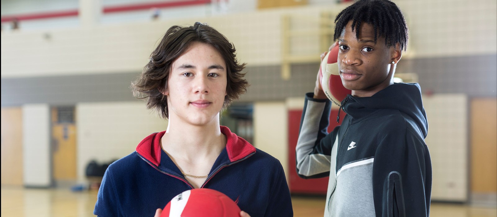 Two students holding volleyballs